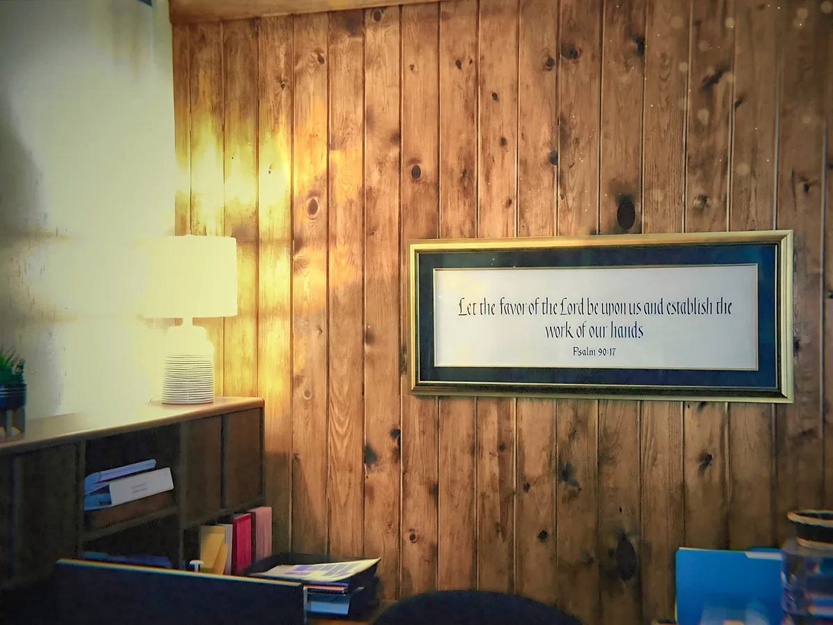 A framed Psalm 90:17 verse on a knotty pine wall